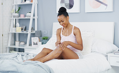Buy stock photo Woman, leg and moisturizer in bed for body care and cleaning in a home in morning lotion. Smile, relax and skincare with happy African female person with skin beauty and cosmetics cream in a house