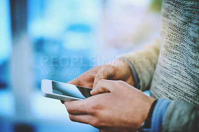 Buy stock photo Shot of an unrecognizable businessman using his cellphone at work