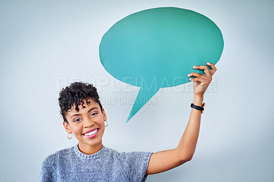 Buy stock photo Portrait of an attractive young woman holding up a speech bubble against a blue background