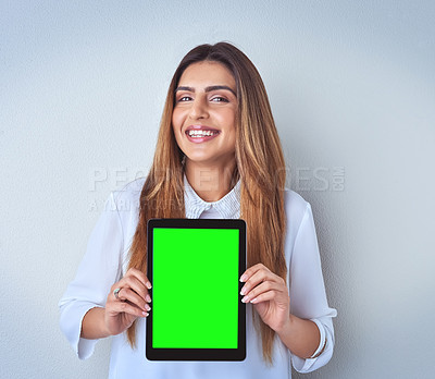 Buy stock photo Portrait of an attractive young woman holding a digital tablet against a blue background