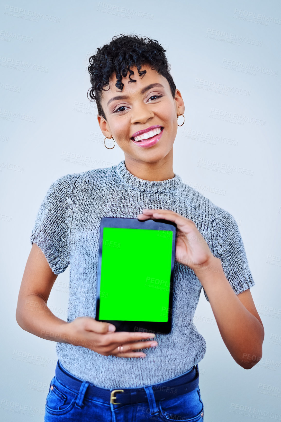 Buy stock photo Portrait of an attractive young woman holding up a digital tablet against a blue background