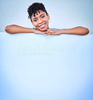 Buy stock photo Portrait of an attractive young woman posing against a blue background