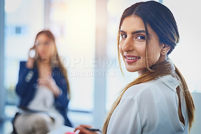 Buy stock photo Portrait of an attractive young businesswoman taking down notes on her notepad during a meeting with her colleagues at work