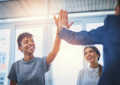 Buy stock photo Shot of an attractive young businesswoman getting a high five from her colleague during a meeting at work