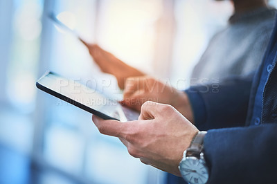 Buy stock photo Closeup shot of two unrecognizable businesspeople using their digital tablets during a meeting at work