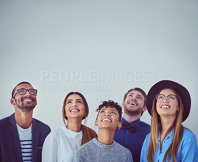Buy stock photo Studio shot of a group of young businesspeople looking up while standing against a grey background