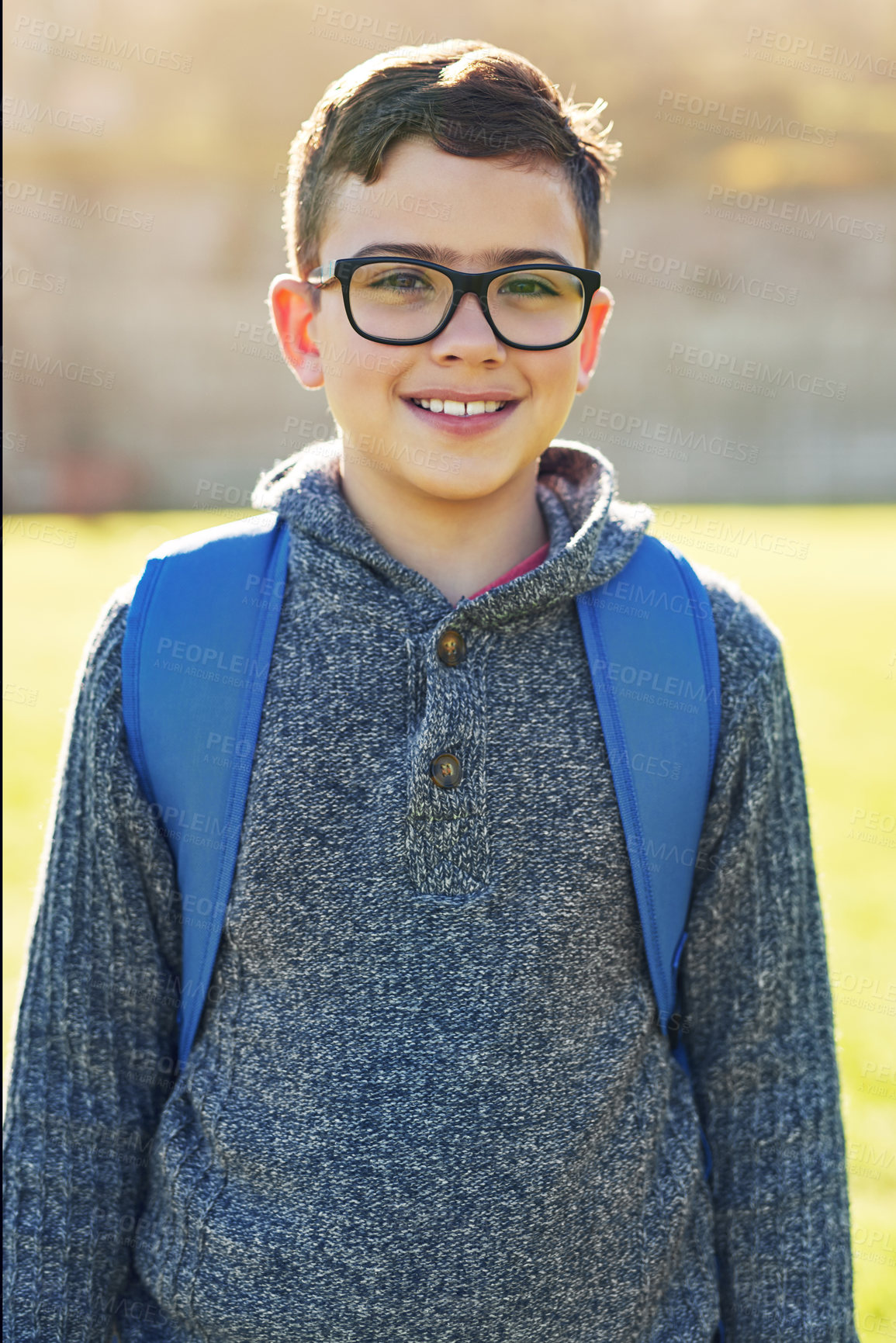 Buy stock photo Portrait of an elementary schoolboy standing on the school lawn outside