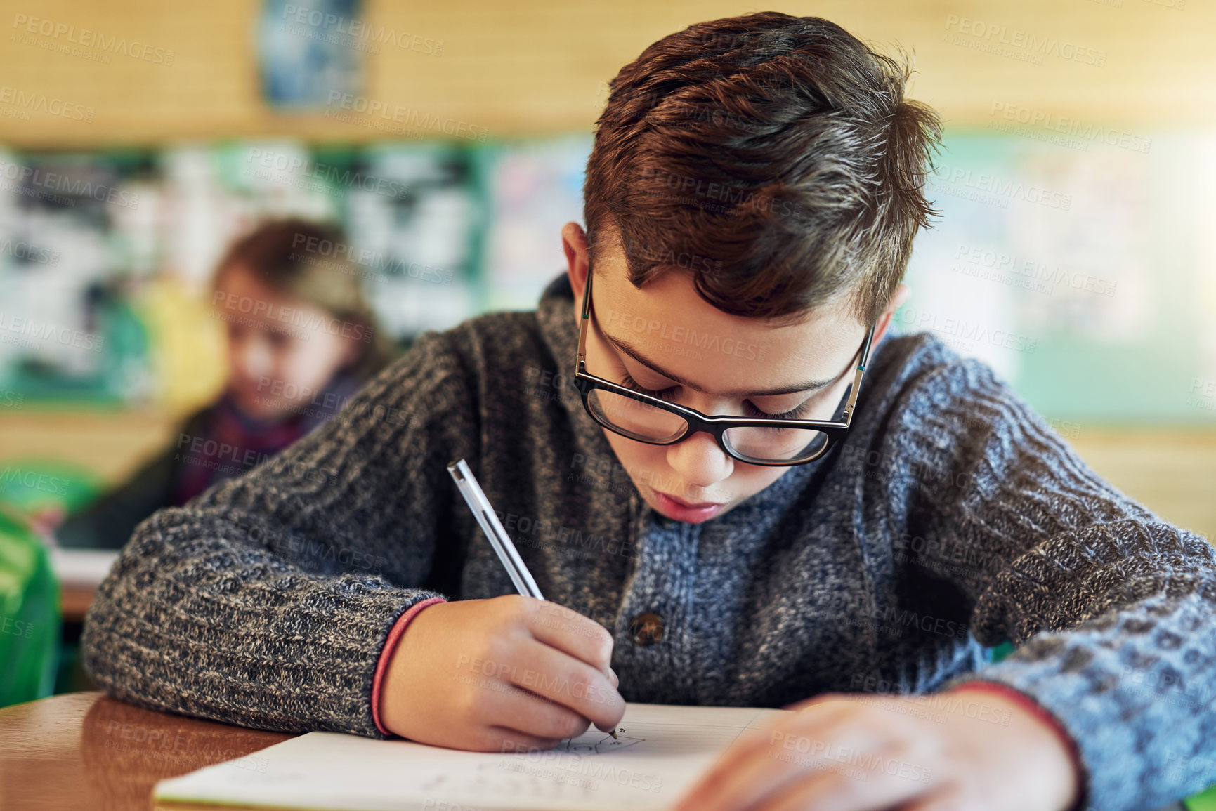 Buy stock photo Shot of an elementary schoolboy working in class