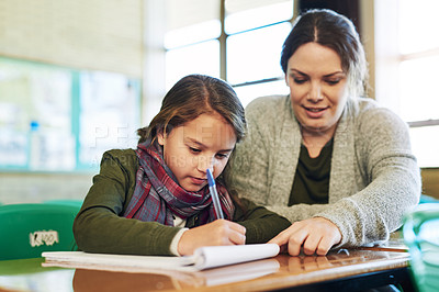 Buy stock photo Shot of an elementary school girl getting help from her teacher in class