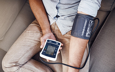 Buy stock photo Hypertension, machine and man test blood pressure in a home sofa or living room for medical or health exam. Monitor, reading and person in a lounge equipment for chronic disease due to stress