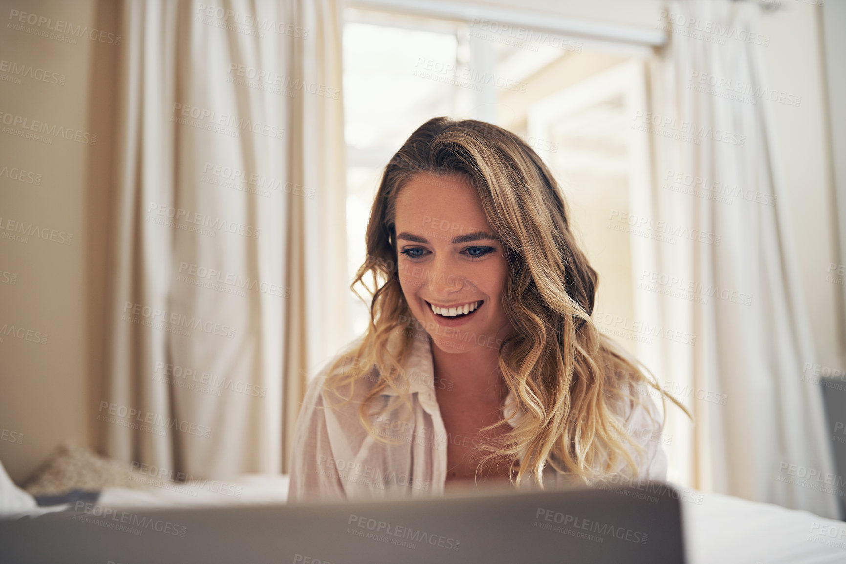 Buy stock photo Shot of a relaxed young woman using a laptop in her bedroom at home