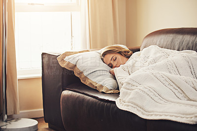 Buy stock photo Shot of a young woman sleeping peacefully on the sofa at home