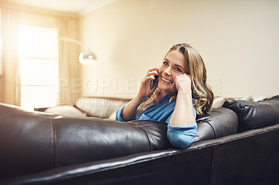 Buy stock photo Shot of a relaxed young woman using a smartphone on the sofa at home