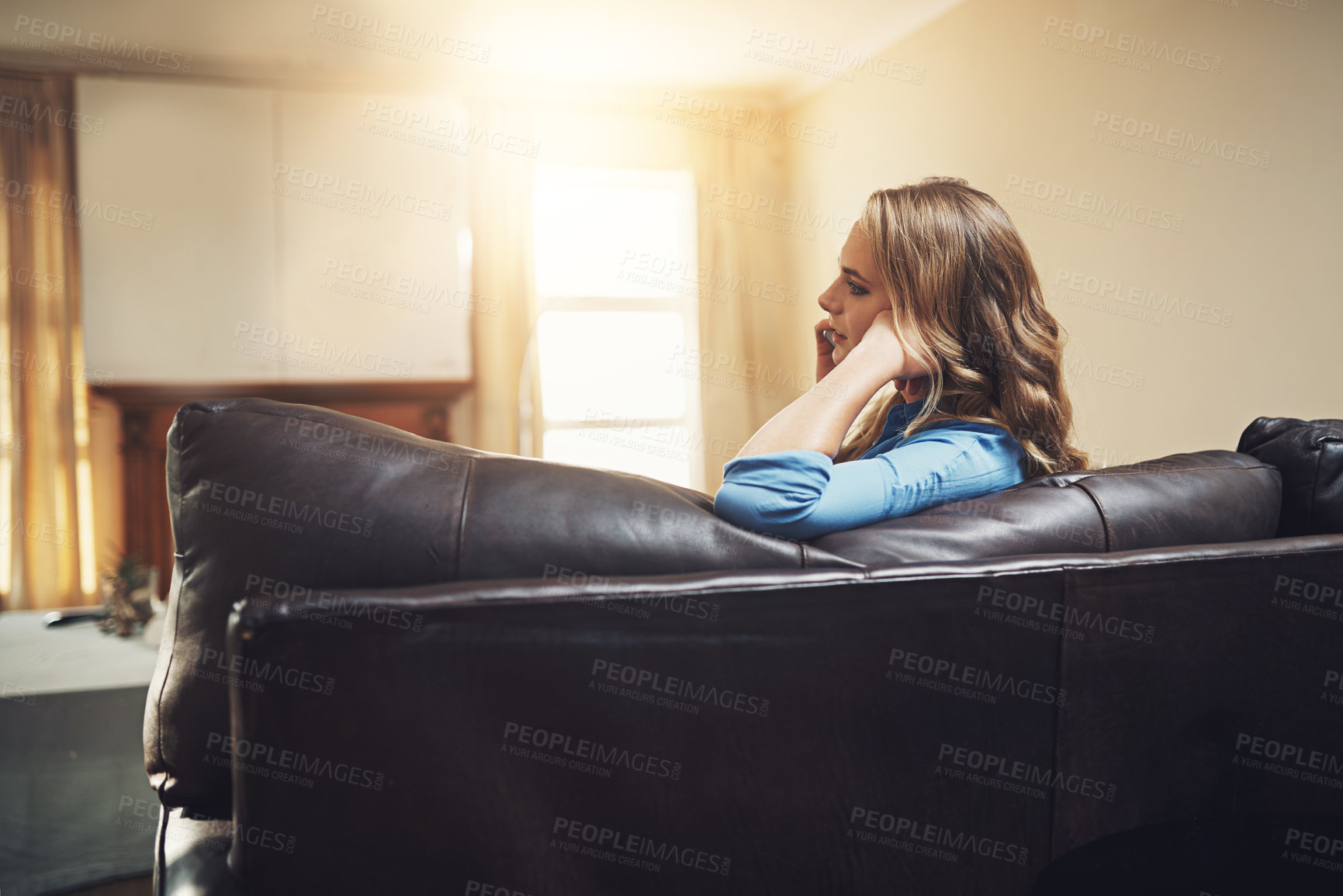 Buy stock photo Shot of a relaxed young woman using a smartphone on the sofa at home