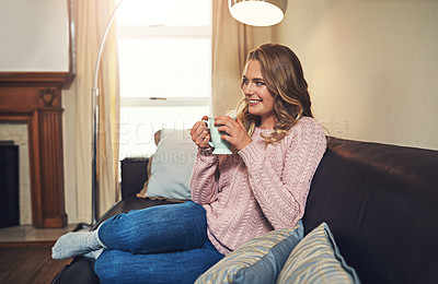 Buy stock photo Shot of a relaxed young woman having coffee on the sofa at home