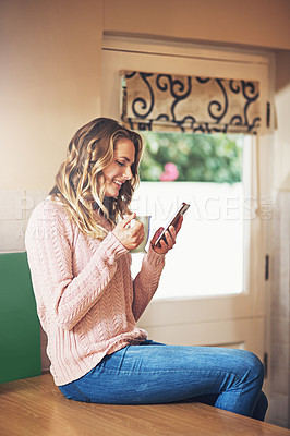 Buy stock photo Shot of a relaxed young woman having coffee and using a digital tablet at home