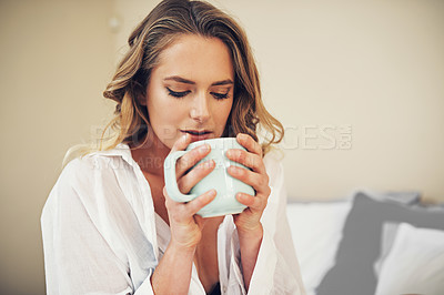 Buy stock photo Shot of a relaxed young woman having coffee in her bedroom at home
