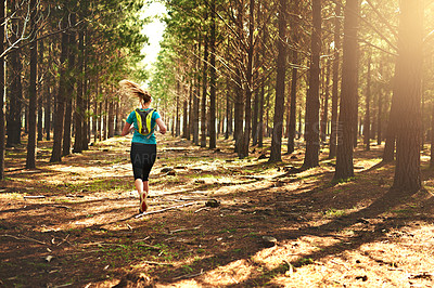 Buy stock photo Shot of a young woman out running in the forest
