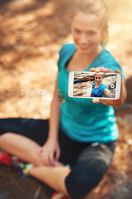 Buy stock photo Shot of a sporty young woman using her cellphone while out in nature
