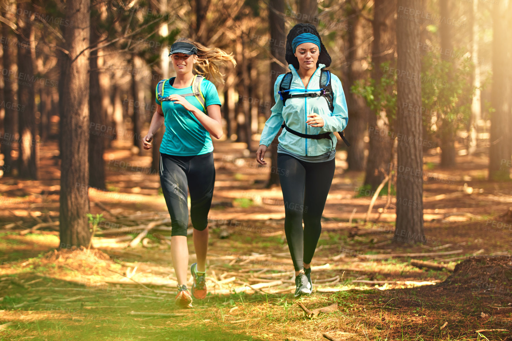 Buy stock photo Shot of two sporty young women out exercising in nature