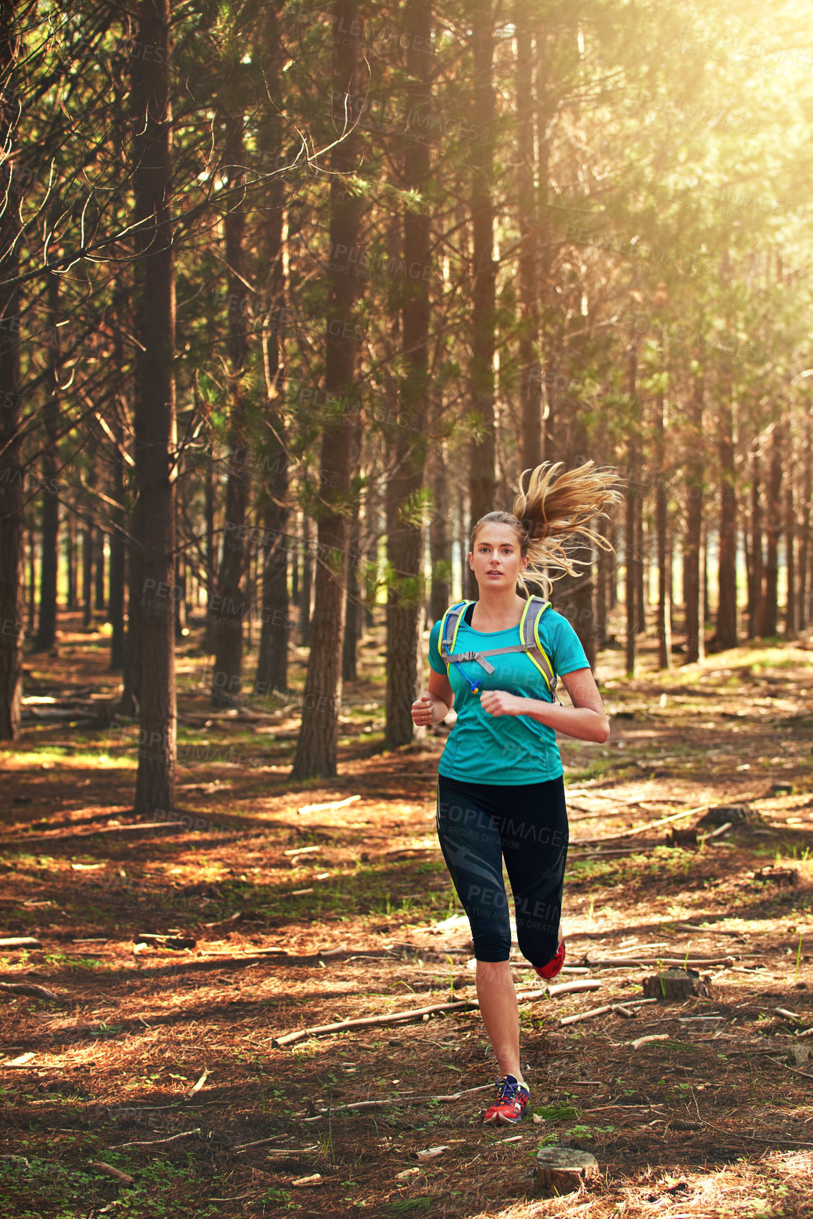 Buy stock photo Shot of a young woman out running in the forest
