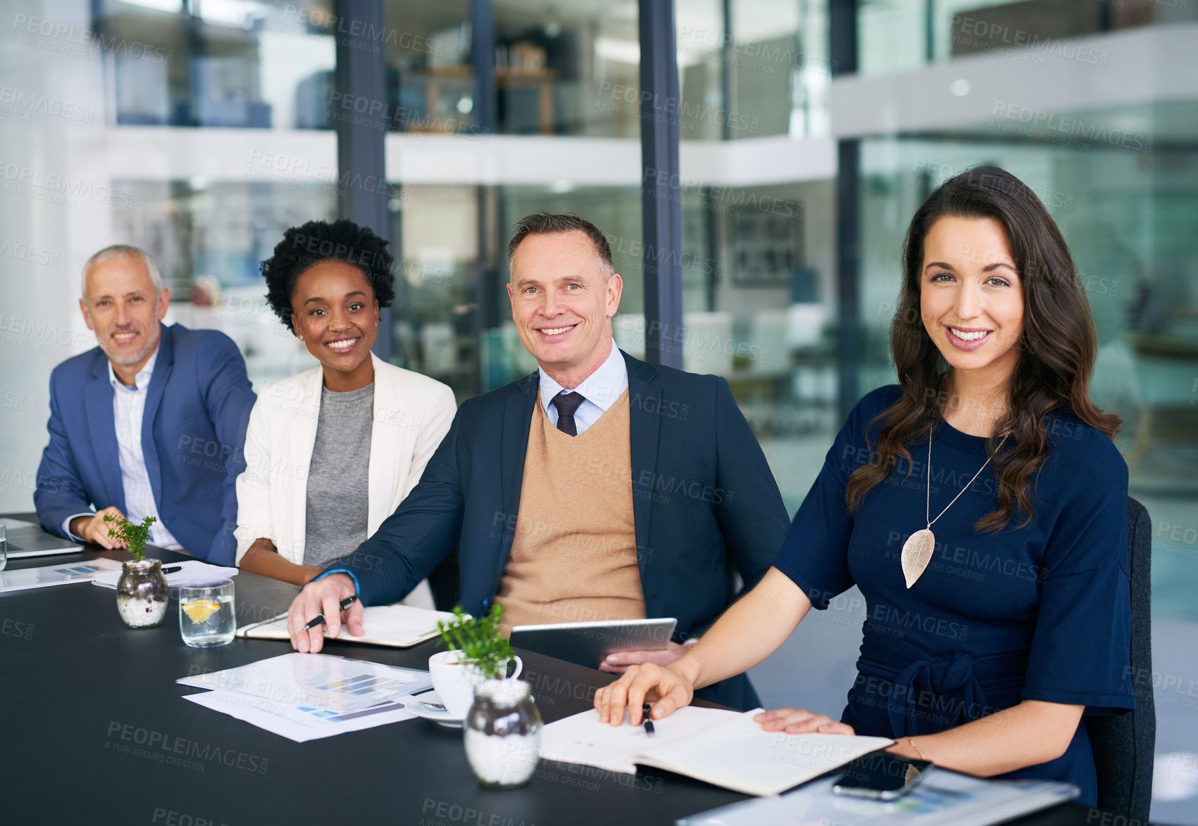 Buy stock photo Cropped portrait of a diverse group of businesspeople sitting together in a boardroom