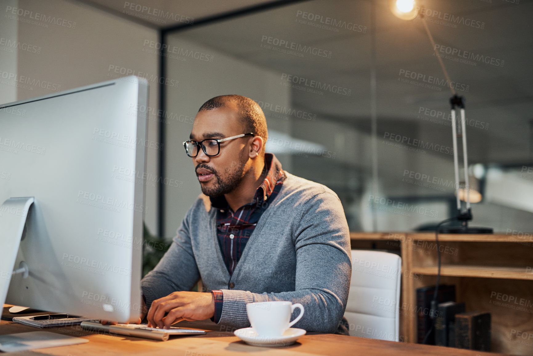 Buy stock photo Shot of a focused young businessman working in his office