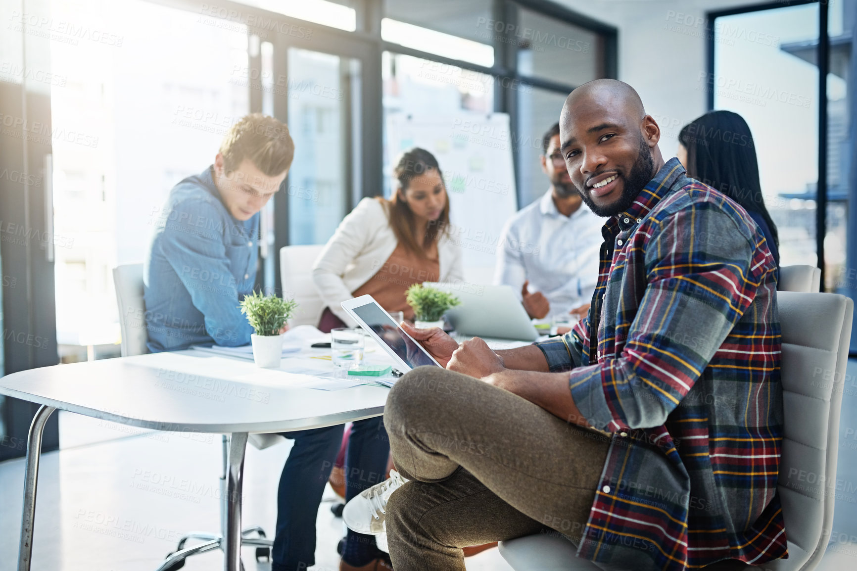 Buy stock photo Shot of a group of young businesspeople discussing ideas with each other during a meeting in a modern office