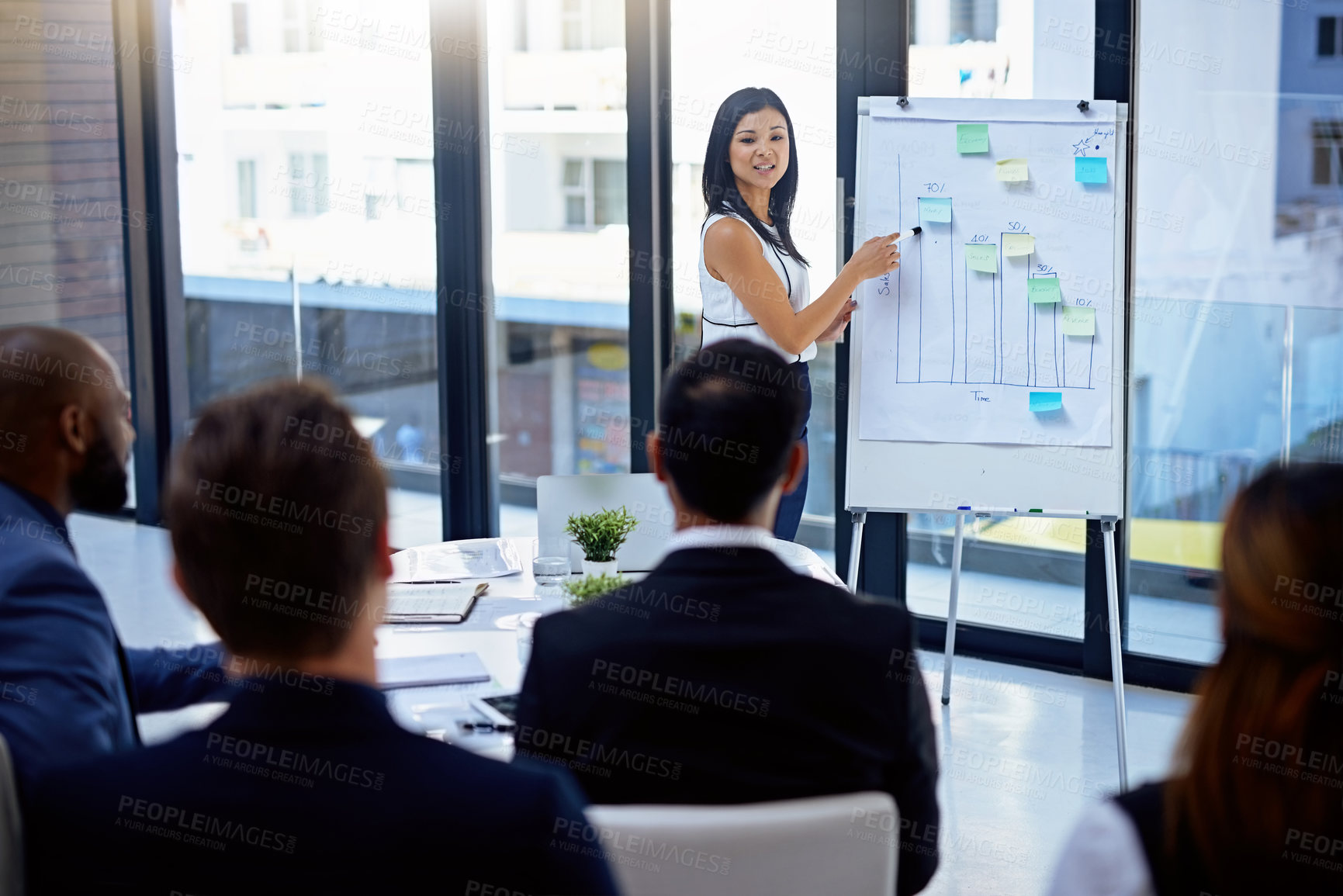 Buy stock photo Shot of a young businesswoman giving a demonstration on a white board to her colleagues in a modern office