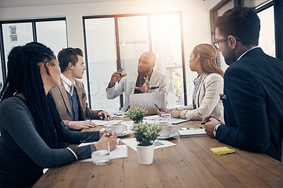 Buy stock photo Shot of a group of young businesspeople having a meeting in a modern office