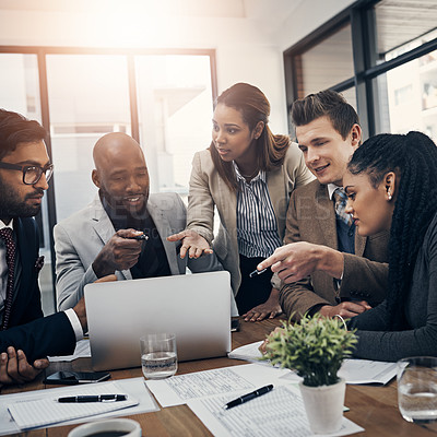 Buy stock photo Shot of a group of young businesspeople using a laptop together during a meeting in a modern office