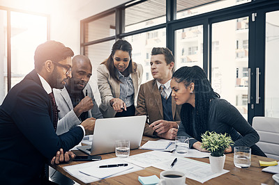 Buy stock photo Shot of a group of young businesspeople using a laptop together during a meeting in a modern office