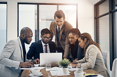 Buy stock photo Shot of a group of young businesspeople using a laptop together during a meeting in a modern office