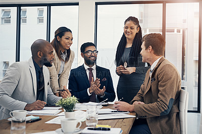 Buy stock photo Shot of a group of young businesspeople having a meeting in a modern office