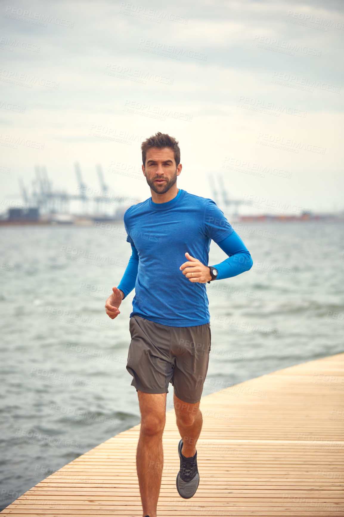 Buy stock photo Shot of a sporty middle-aged man out running by the seaside