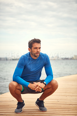Buy stock photo Shot of a sporty man taking a break after his run