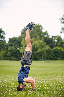 Buy stock photo Shot of a sporty middle-aged man doing a headstand