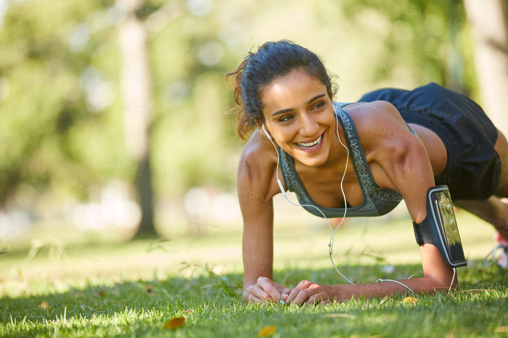 Buy stock photo Shot of a beautiful young woman exercising outdoors on a sunny day