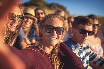 Buy stock photo Cropped portrait of an attractive young woman taking a selfie with her friends at the beach