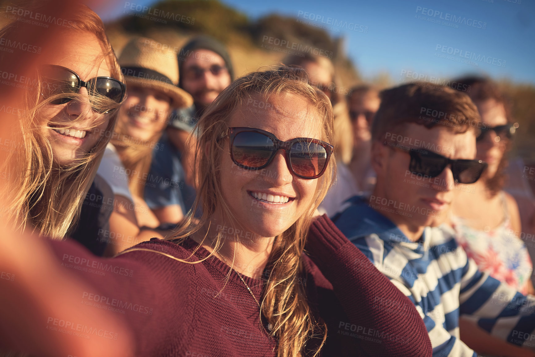 Buy stock photo Cropped portrait of an attractive young woman taking a selfie with her friends at the beach