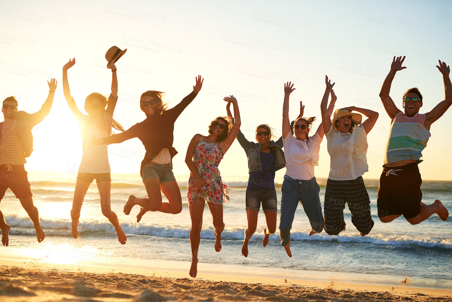Buy stock photo Full length shot of a group of young friends jumping into the air at the beach