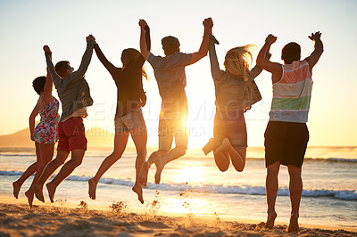 Buy stock photo Rearview shot of a group of young friends jumping into the air while holding hands at the beach