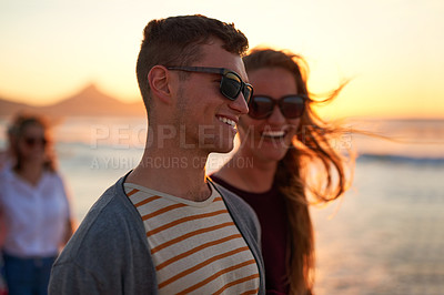 Buy stock photo Cropped shot of an affectionate young couple taking a walk together on the beach