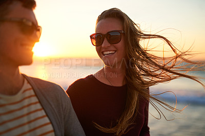 Buy stock photo Cropped shot of an affectionate young couple having a laugh together at the beach