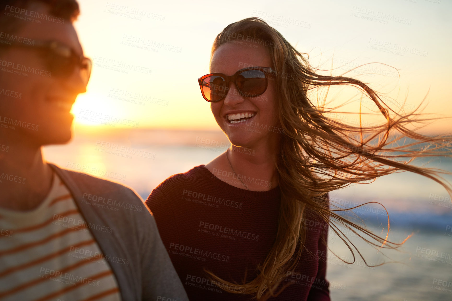 Buy stock photo Couple, happy and travel at beach for sunset, relax and tropical holiday together with sunglasses. Man, woman and walking by ocean for trip, sunshine and summer vacation with weekend date in Ibiza