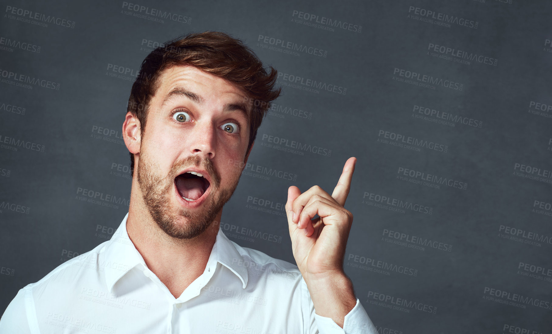 Buy stock photo Surprise, portrait and man in studio, pointing and presenting of news, journalist and mockup. Grey background, idea and hand of promotion, smile and happy with person for announcement and advertising