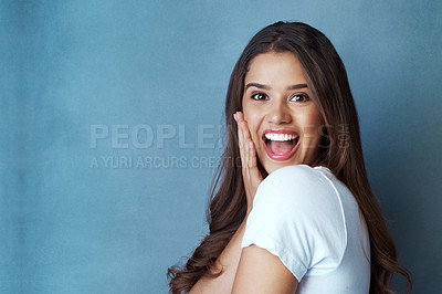 Buy stock photo Studio shot of an attractive young woman looking surprised a blue background