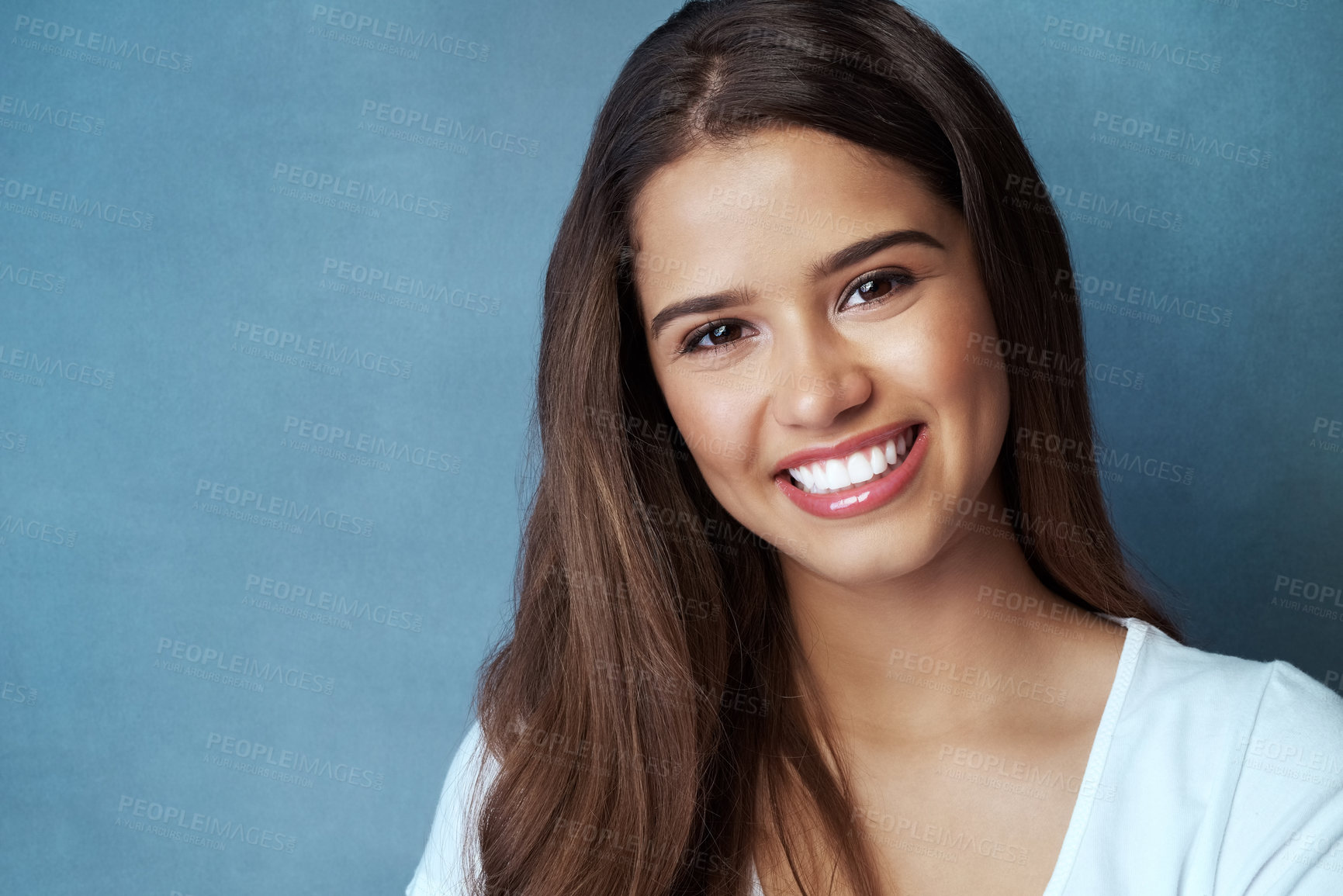 Buy stock photo Happy, smile and portrait of woman on blue background with cheerful, joy and positive expression. Attractive, beauty and face of isolated person smile with confidence, pride and relaxing in studio