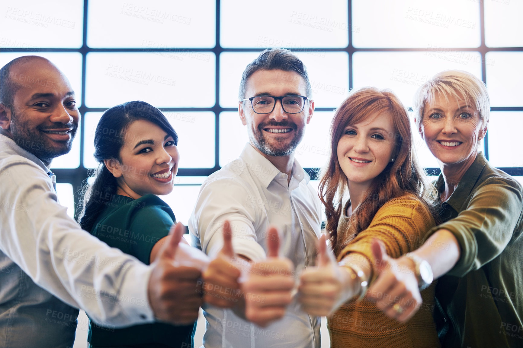 Buy stock photo Cropped portrait of a team of colleagues giving a thumbs up in a modern office