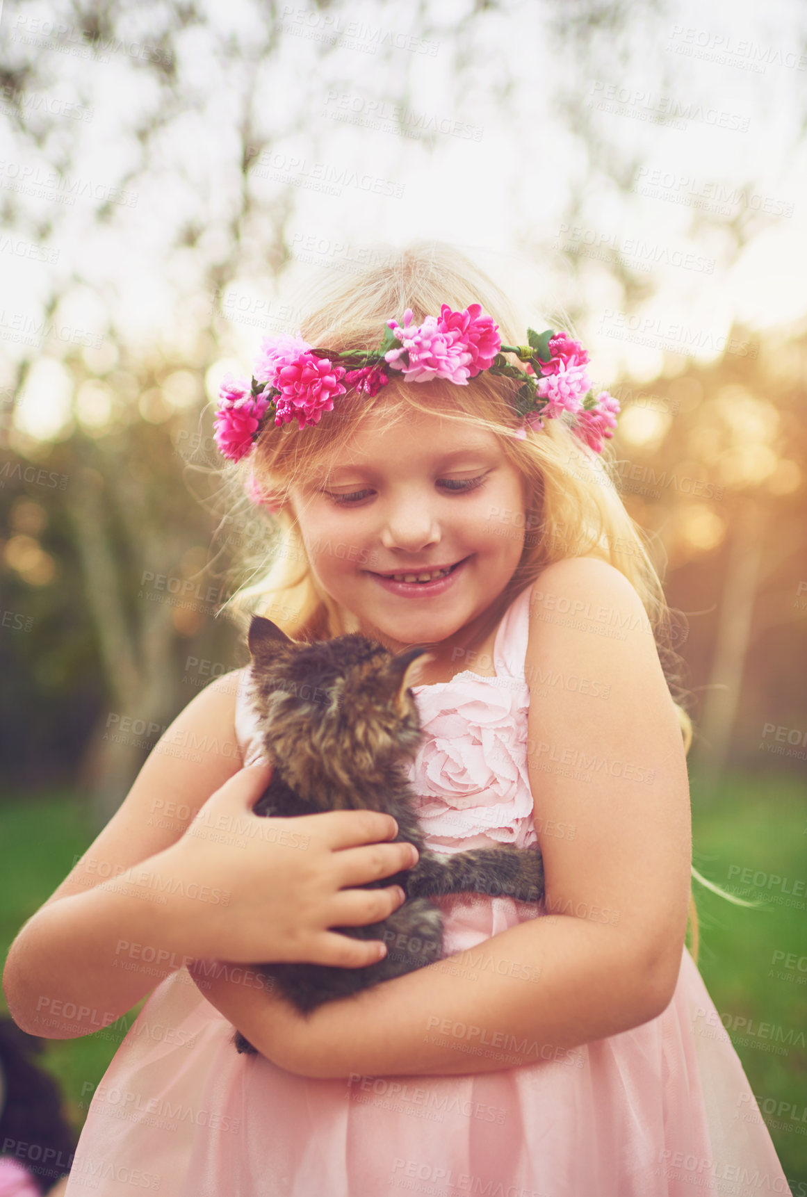 Buy stock photo Shot of a little girl holding a kitten and petting it while standing outside in nature